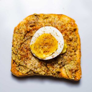 avocado toast with boiled egg on a grey dish