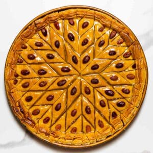 turkish baklava in a copper baking dish on a white surface