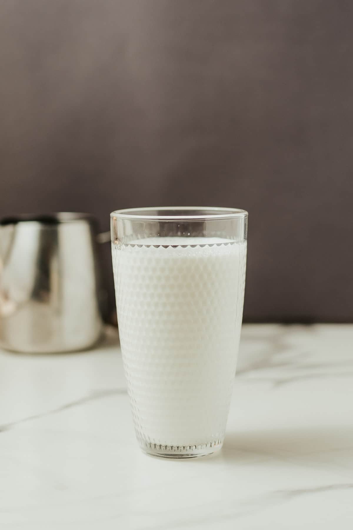 oat milk in glass with dark background