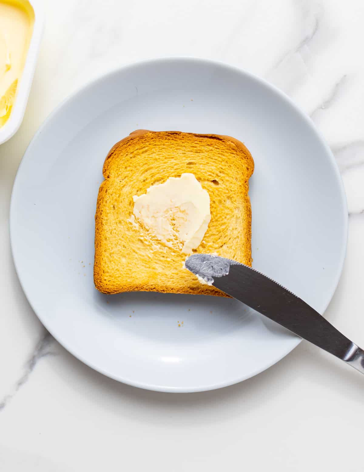 close-up picture of a slice of toast bread in oven with butter on top