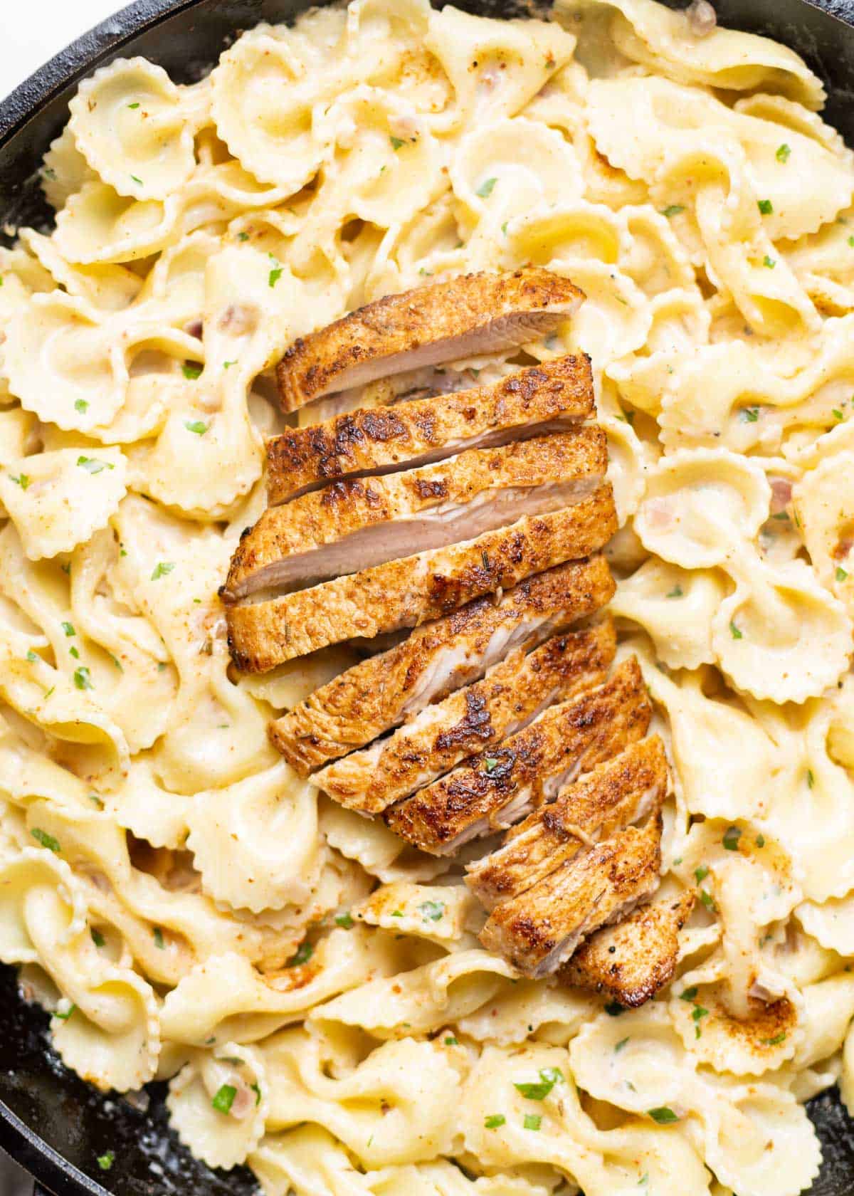 Cajun farfalle alfredo with grilled turkey breast on top.