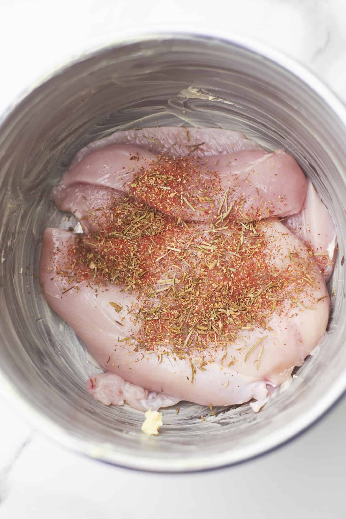 chicken breast in crockpot with seasonings.