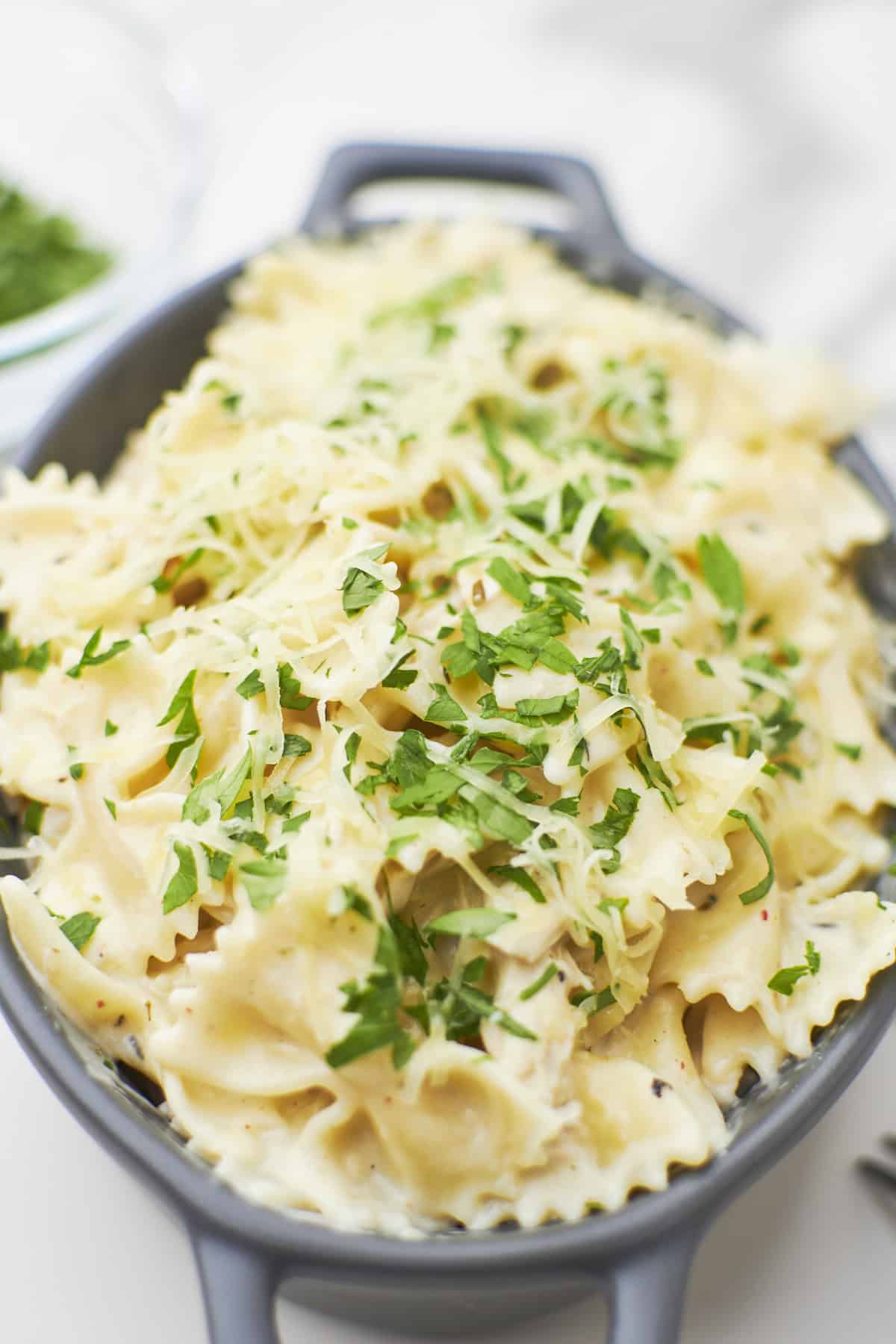 side view of garlic parmesan chicken pasta in serving bowl on countertop.