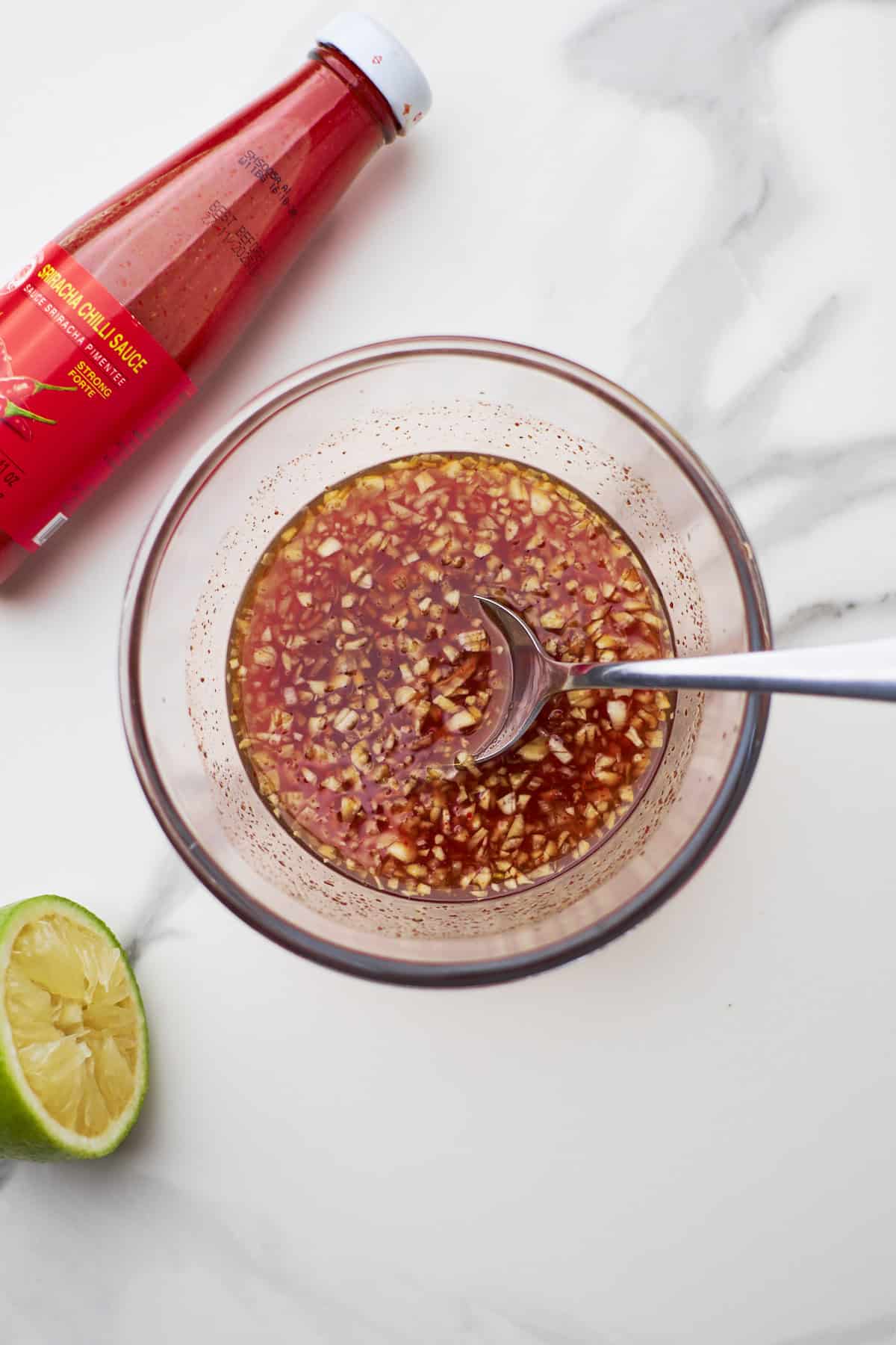 honey sriracha sauce in bowl with spoon.