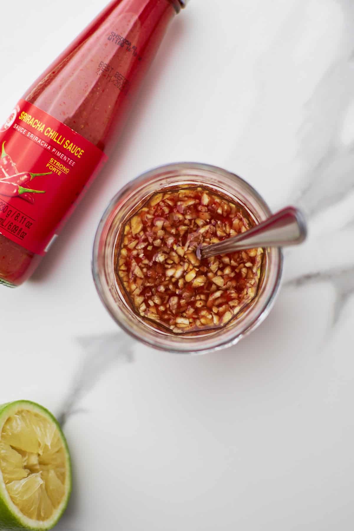 closeup of honey sriracha sauce in a mason jar.