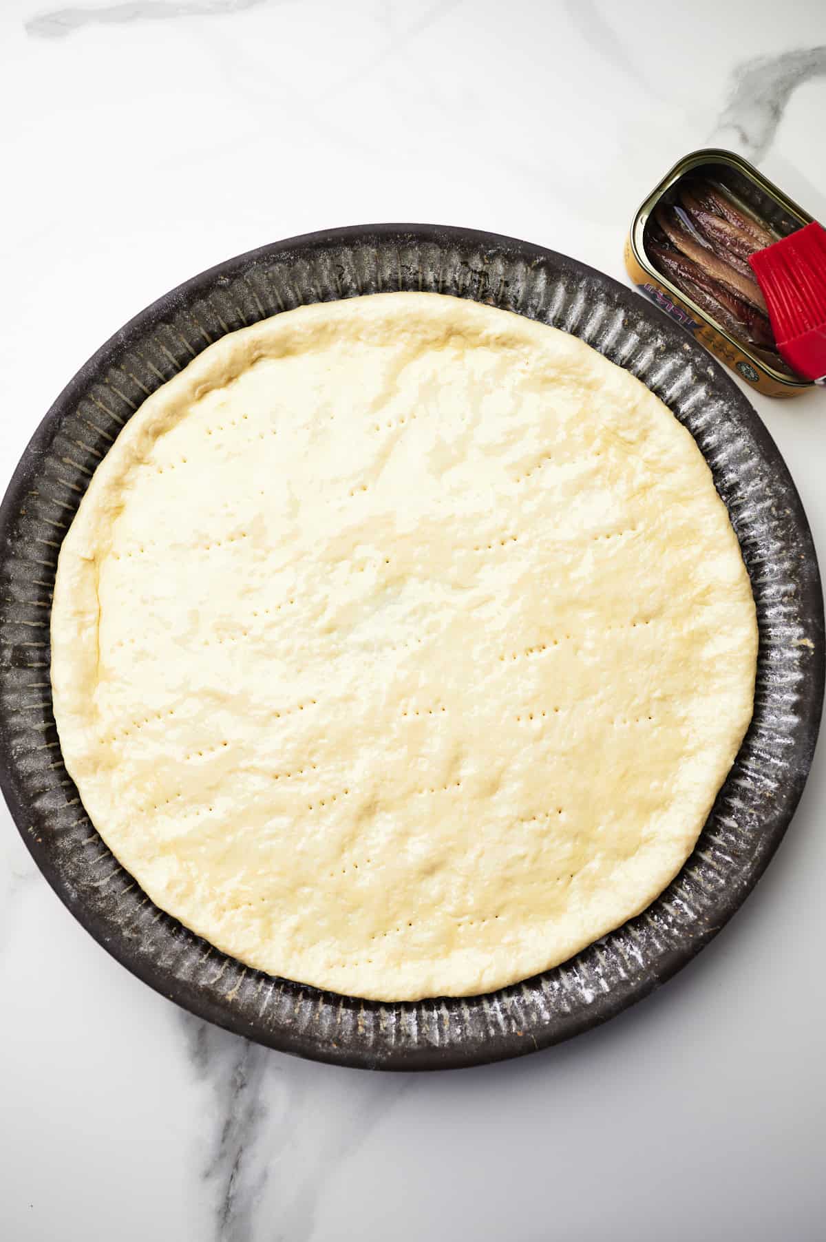 pizza dough, rolled out, oiled and pricked with a fork.