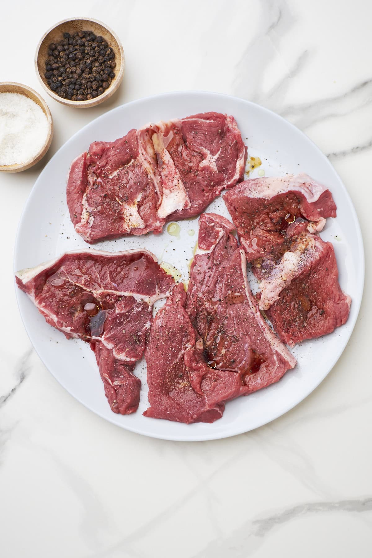 Seasoned steak for steak bagel sandwich on plate.