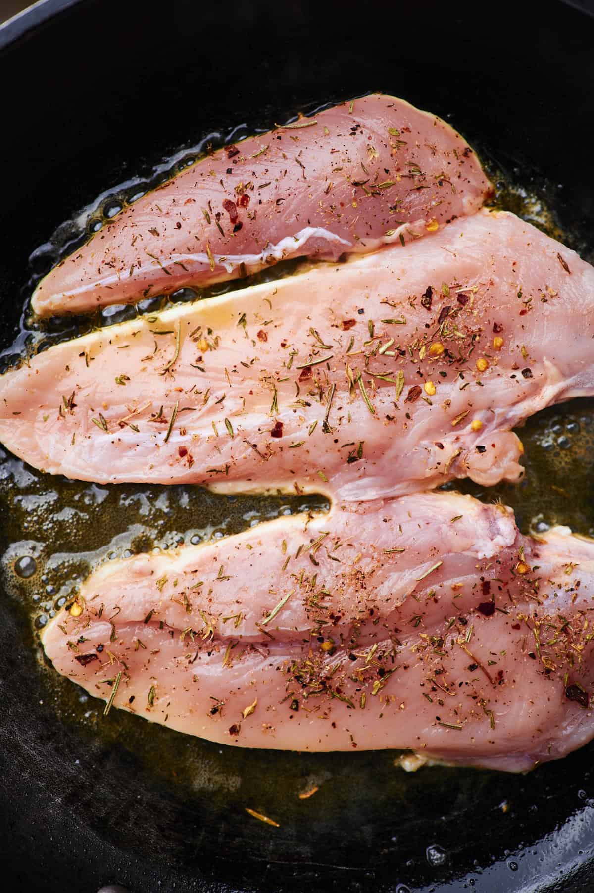 cook seasoned chicken breast on flat top grill.