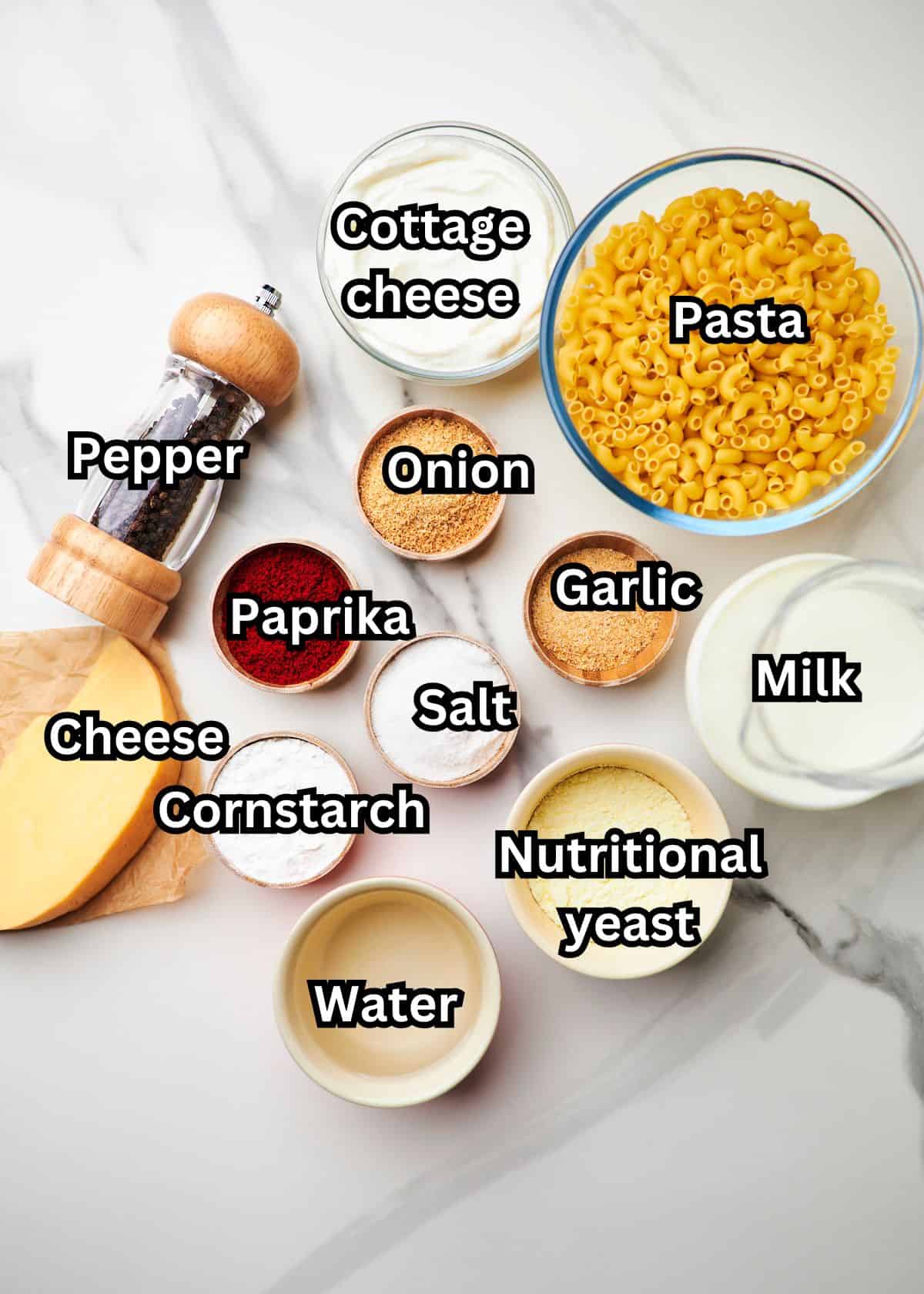 Ingredients including cottage cheese, shredded cheese, pasta, spices, nutritional yeast, cornstarch, milk and pasta water.