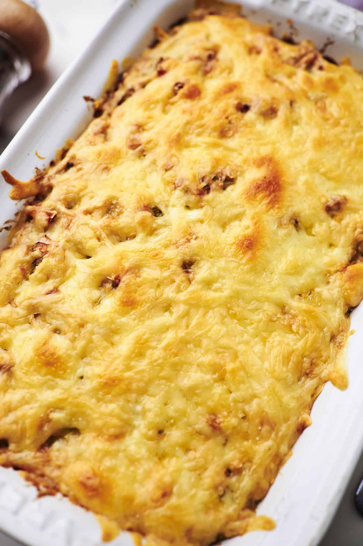 side view of cheesy chicken broccoli and rice casserole in serving dish.