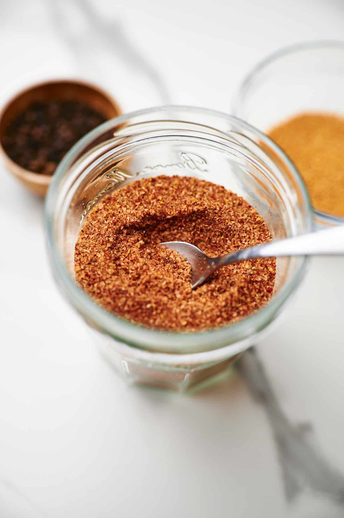 side shot of a mason jar filled with rib rub seasoning.