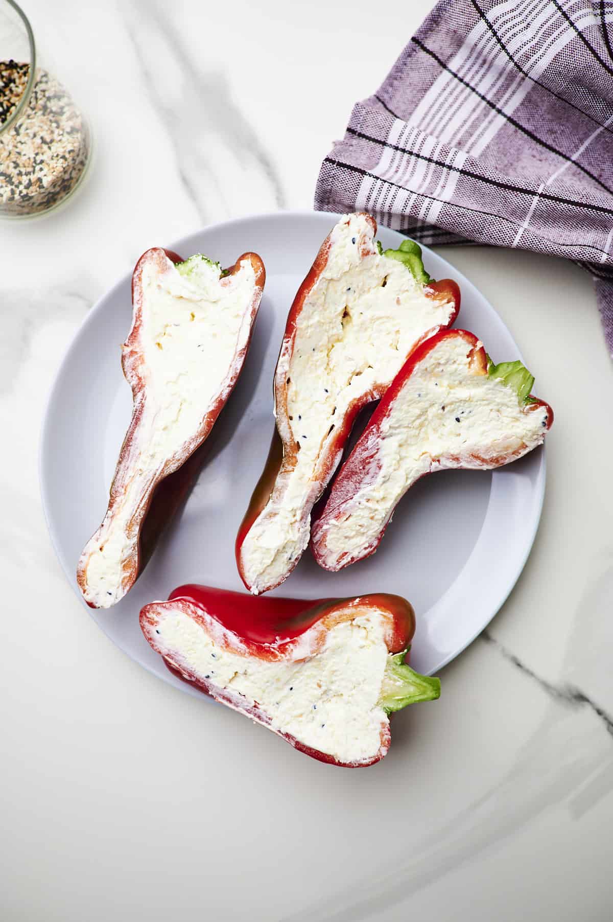 sweet pepper halves on a cutting board filled with a cream cheese mixture