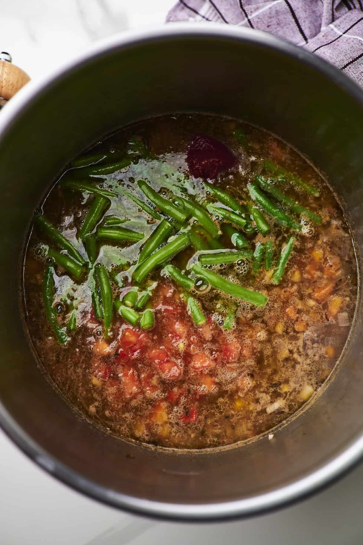 mix green beans and tomatoes into vegetable soup