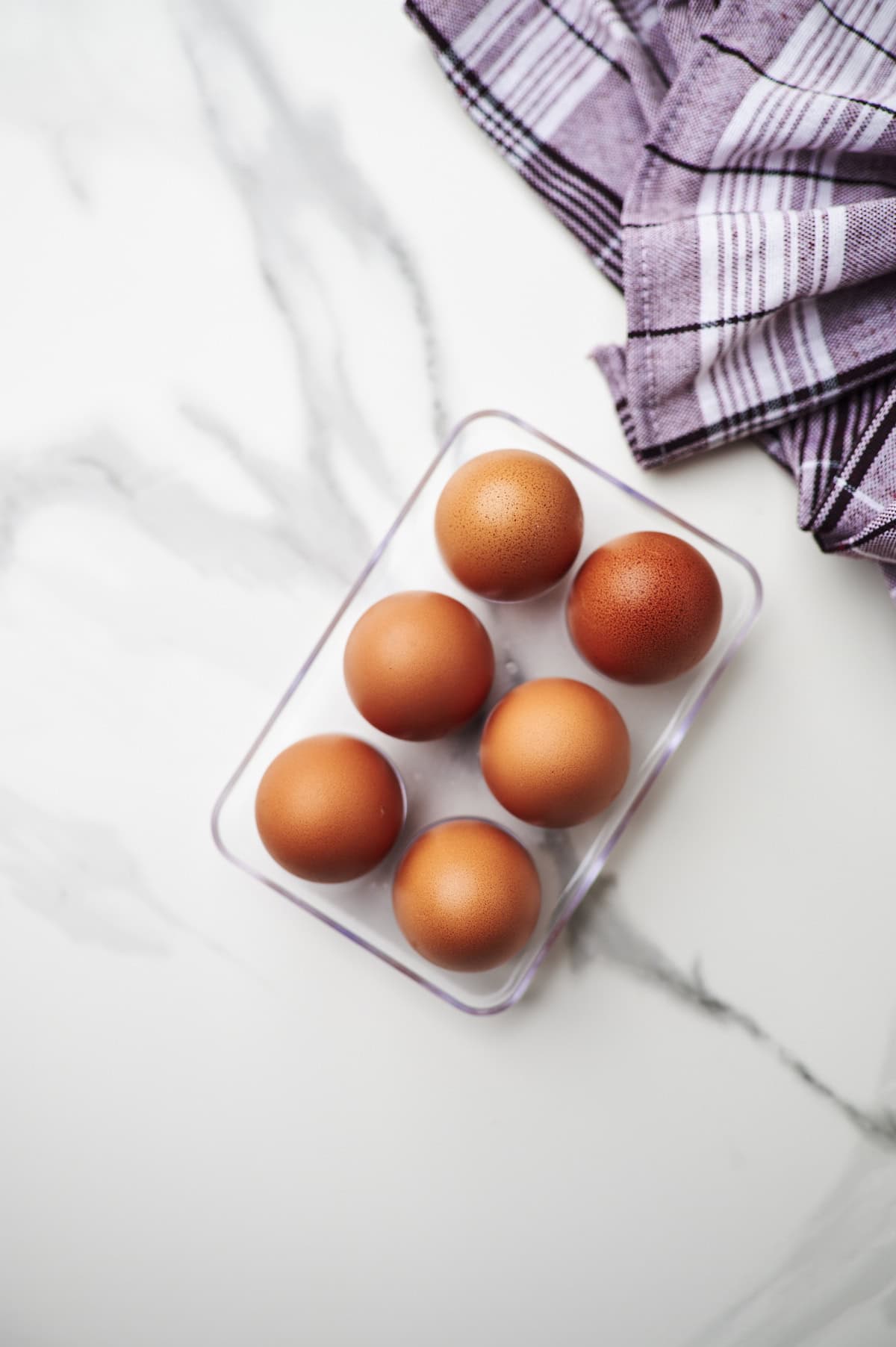 6 eggs on a white counter top. 