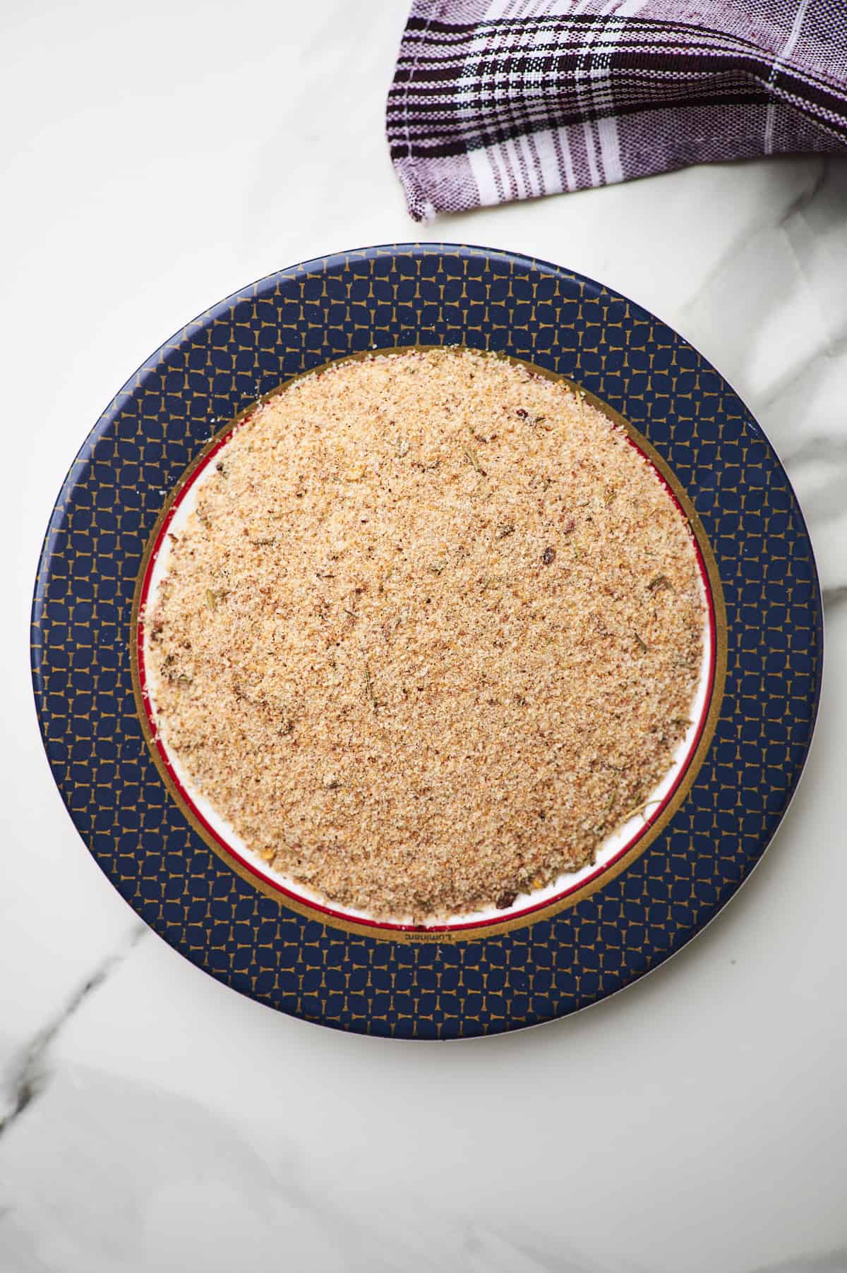 White bowl filled with breadcrumbs and Parmesan cheese.