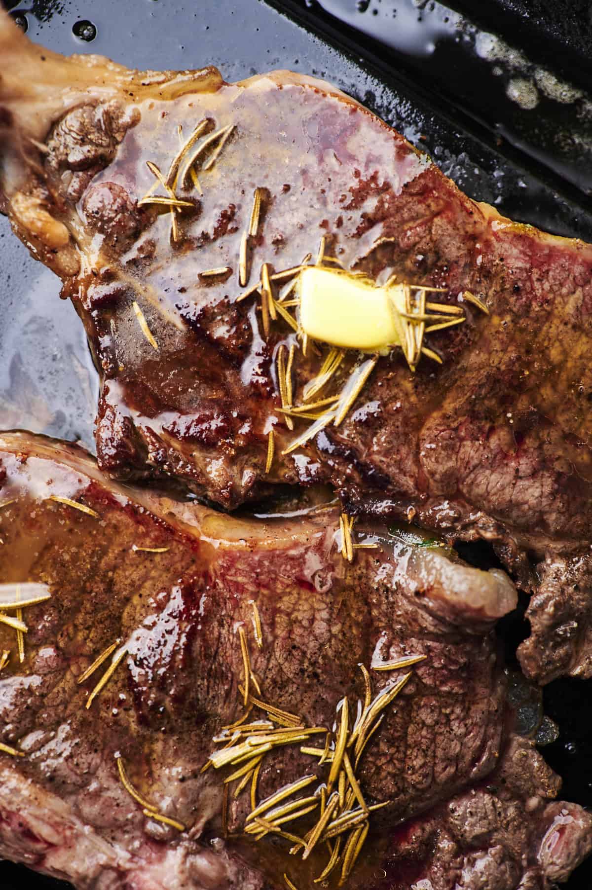 steak with rosemary and thyme on blackstone.