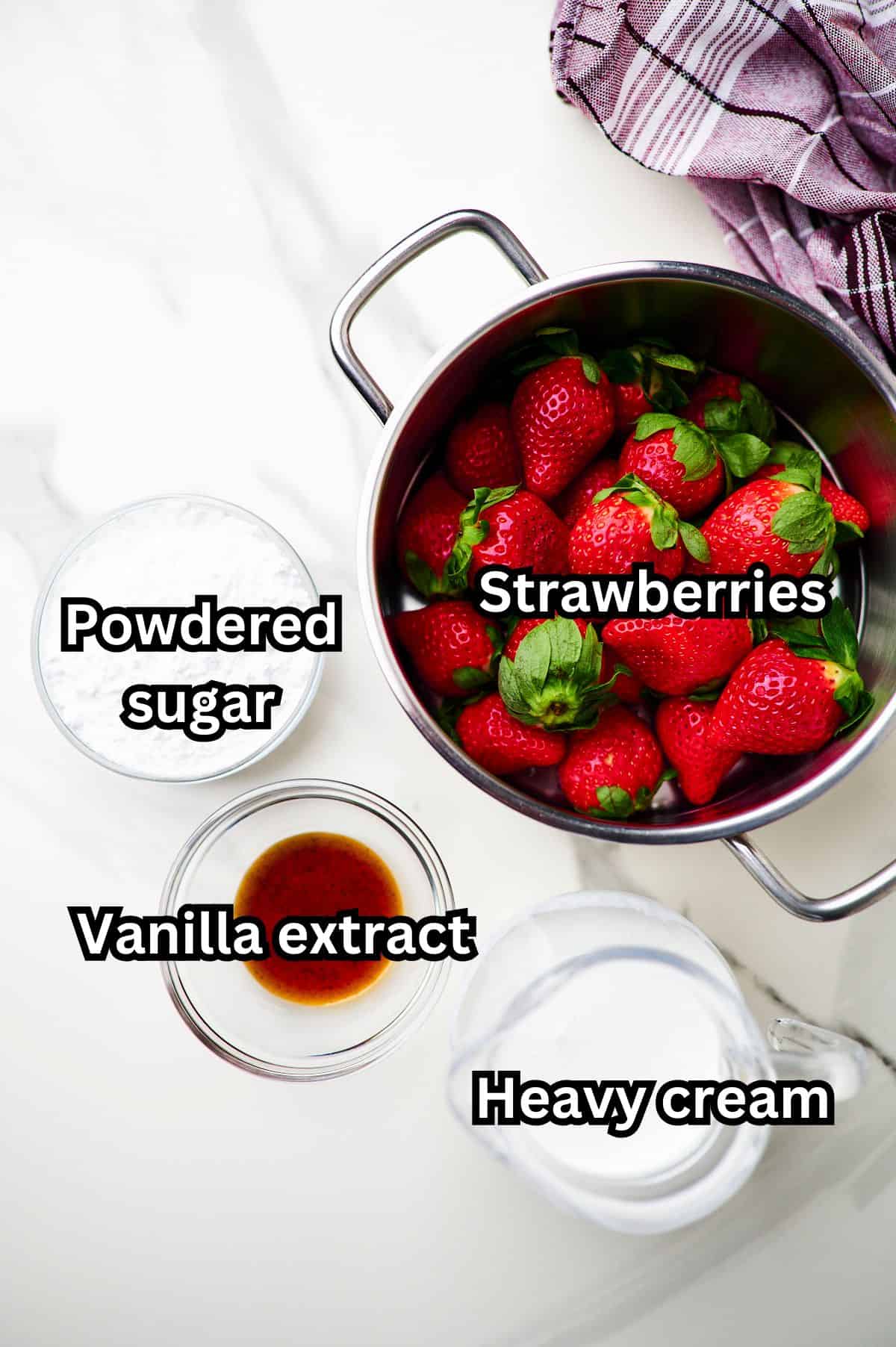 ingredients for strawberry whipped cream frosting on countertop.