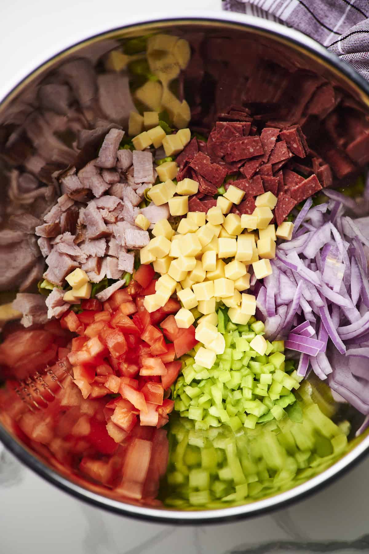 undressed grinder salad in a mixing bowl