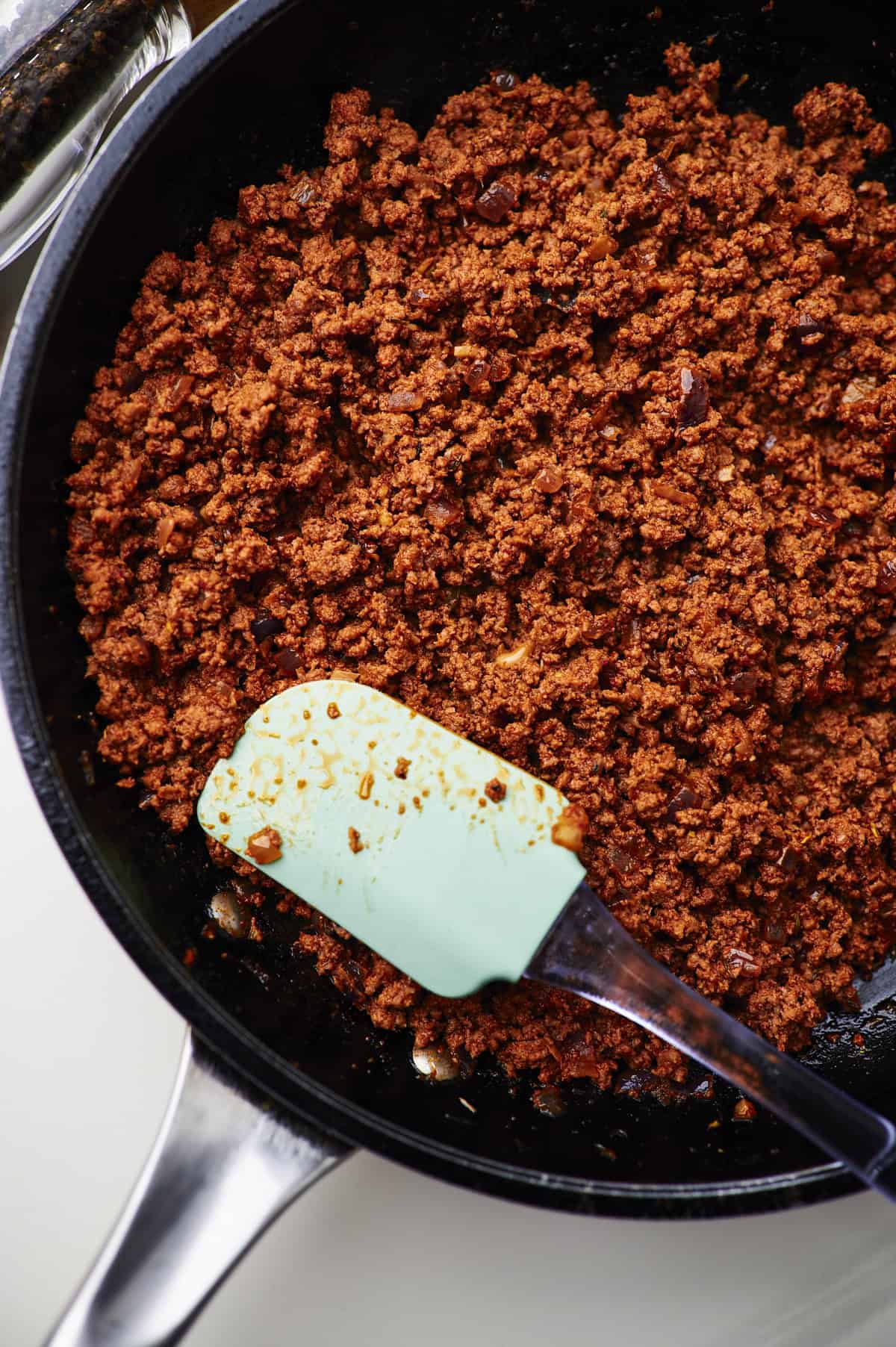 Large pan filled with homemade taco meat and a spoon.