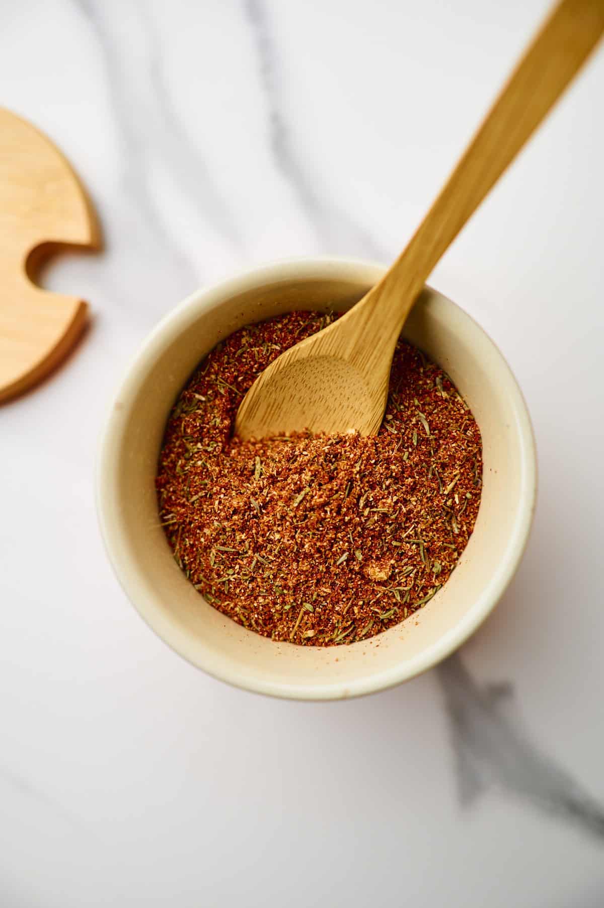 Small bowl filled with homemade taco seasoning and a spoon.