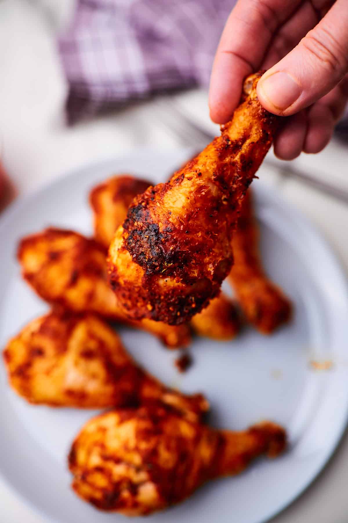 Close up juicy and crispy chicken drumstick with seasonings.