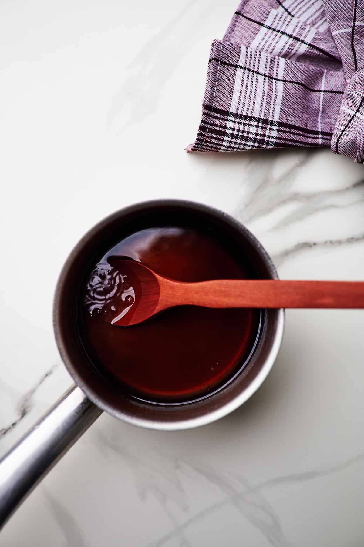 A pan on the stove simmering brown sugar simple syrup.