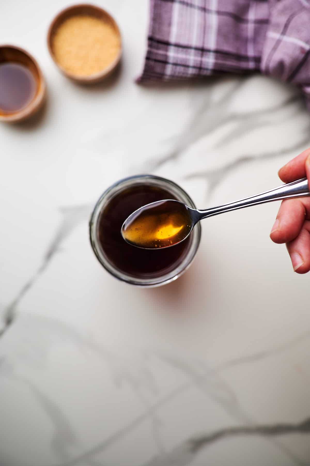 A close up shot of a spoonful of brown sugar syrup.