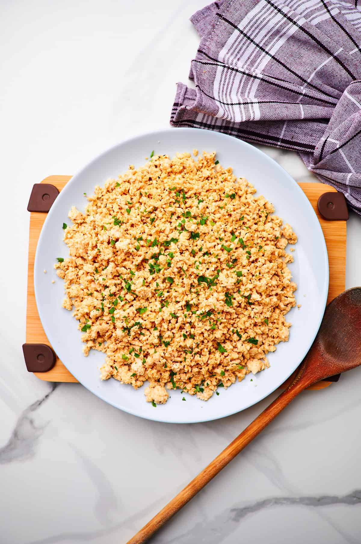 A large serving dish of cooked ground turkey seasoned and garnished with parsley.