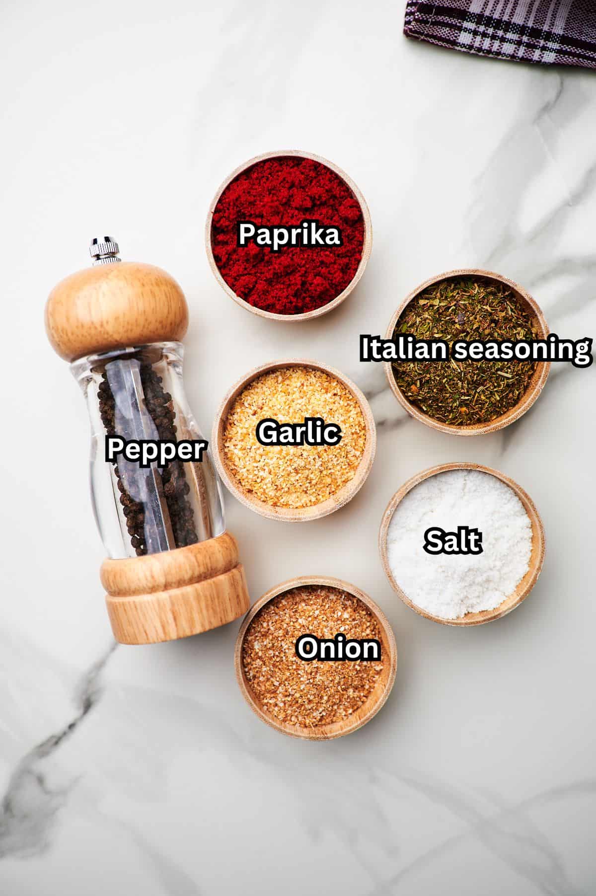 A plate full of different seasonings for ground turkey garlic onion seasoning with each seasoning labeled.