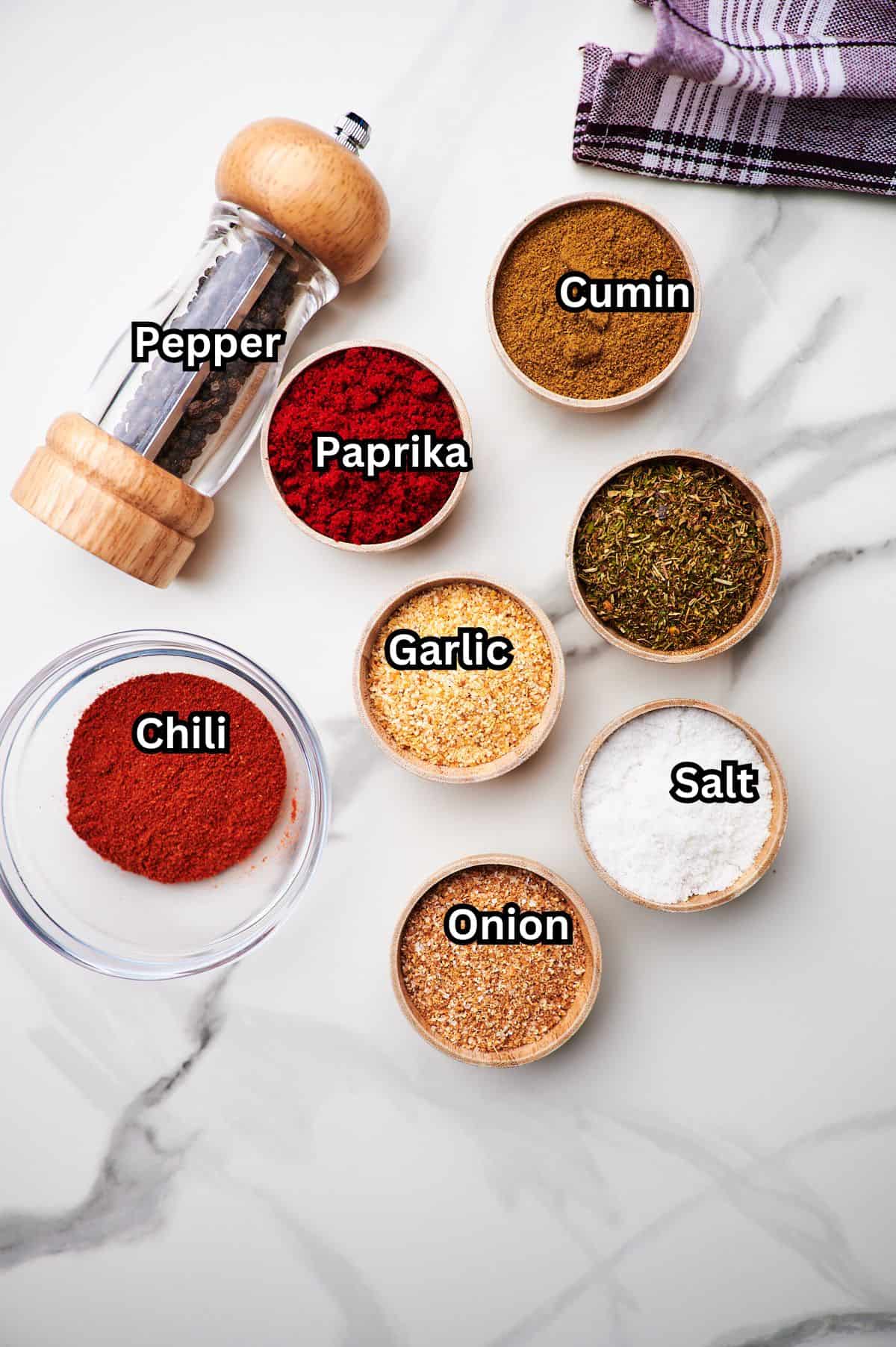 A countertop full of different seasonings for ground turkey taco seasoning with each seasoning labeled.