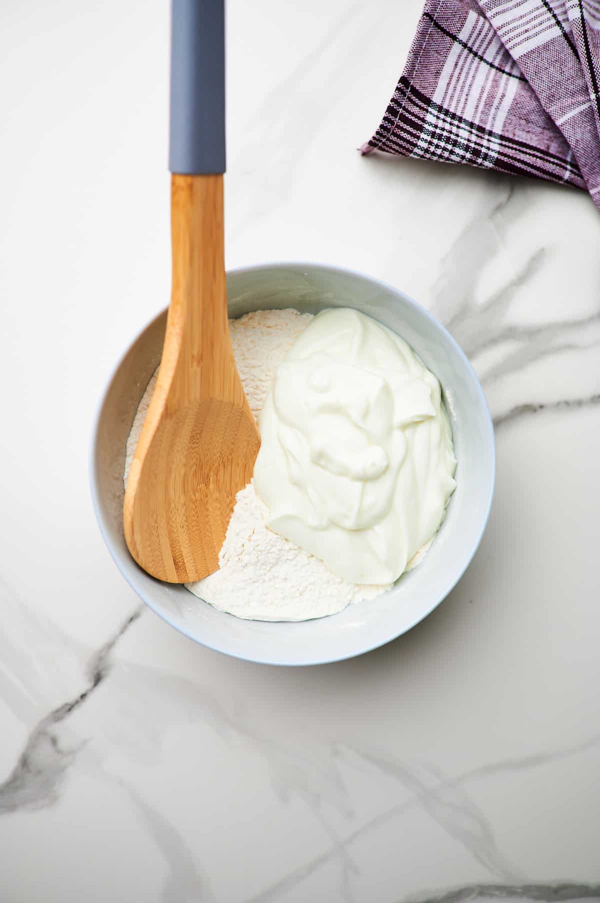 Greek yogurt and self-rising flour in a bowl, not yet mixed.