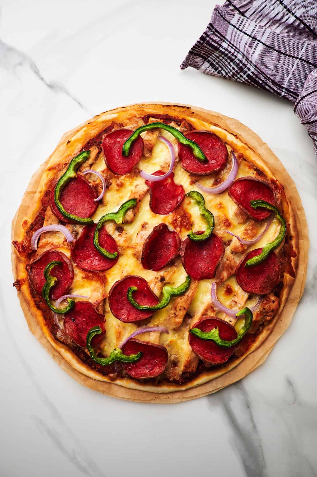 Freshly baked high protein pizza on a piece of parchment paper.