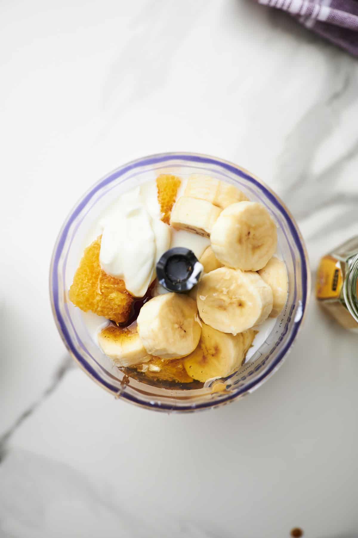 orange, banana, yogurt, honey, almond milk, vanilla, and ice in a blender