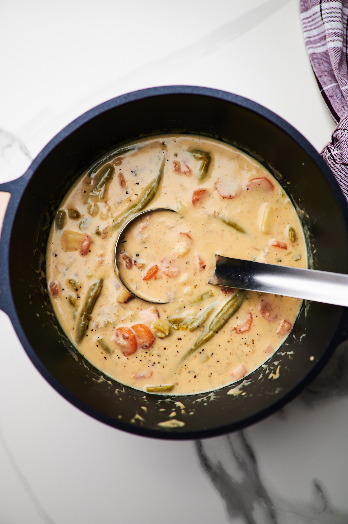 A soup pot filled with creamy chicken stew before and after being cooked.