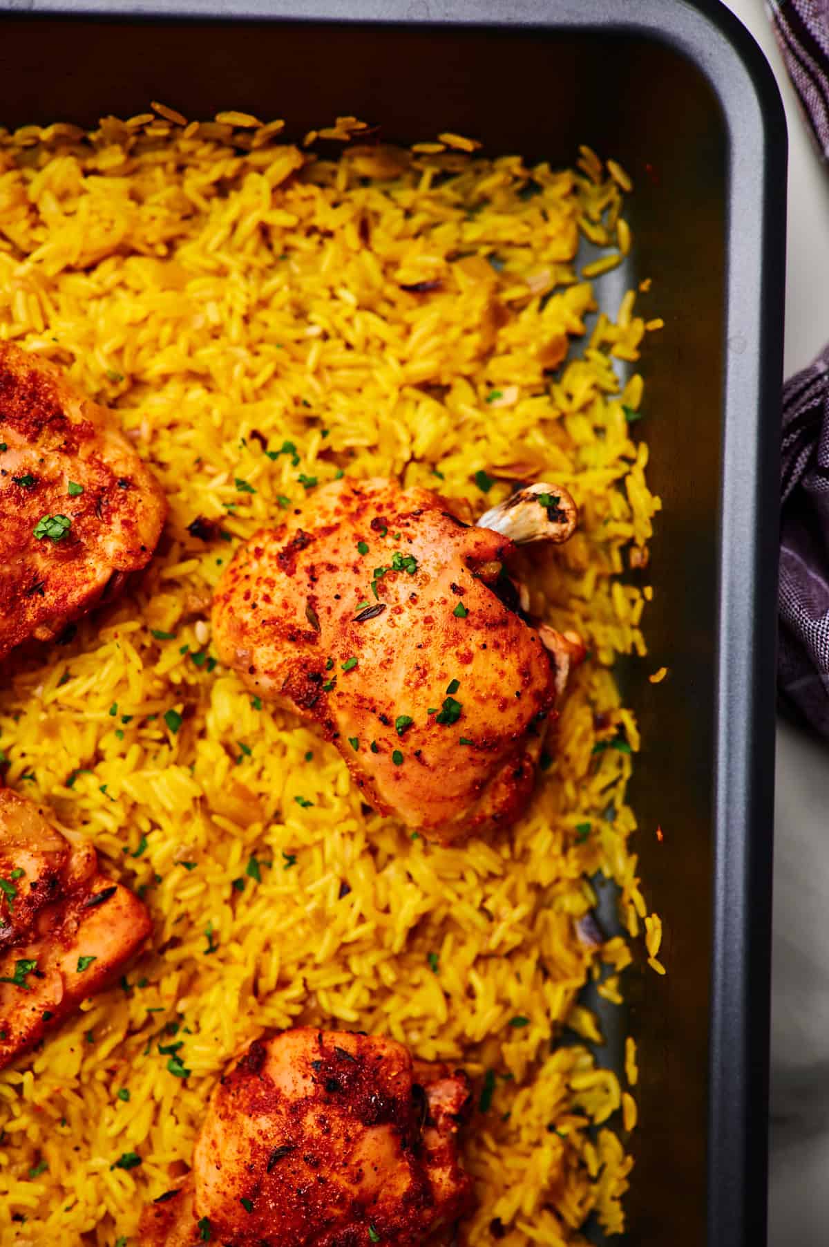 Grey baking dish with Oven Baked Chicken and Rice, ready to be served