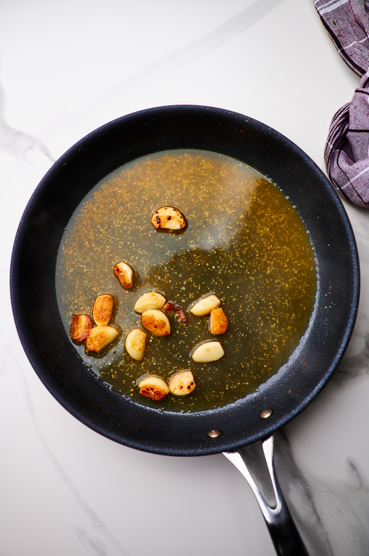 making sauce for creamy garlic chicken in a cast iron skillet