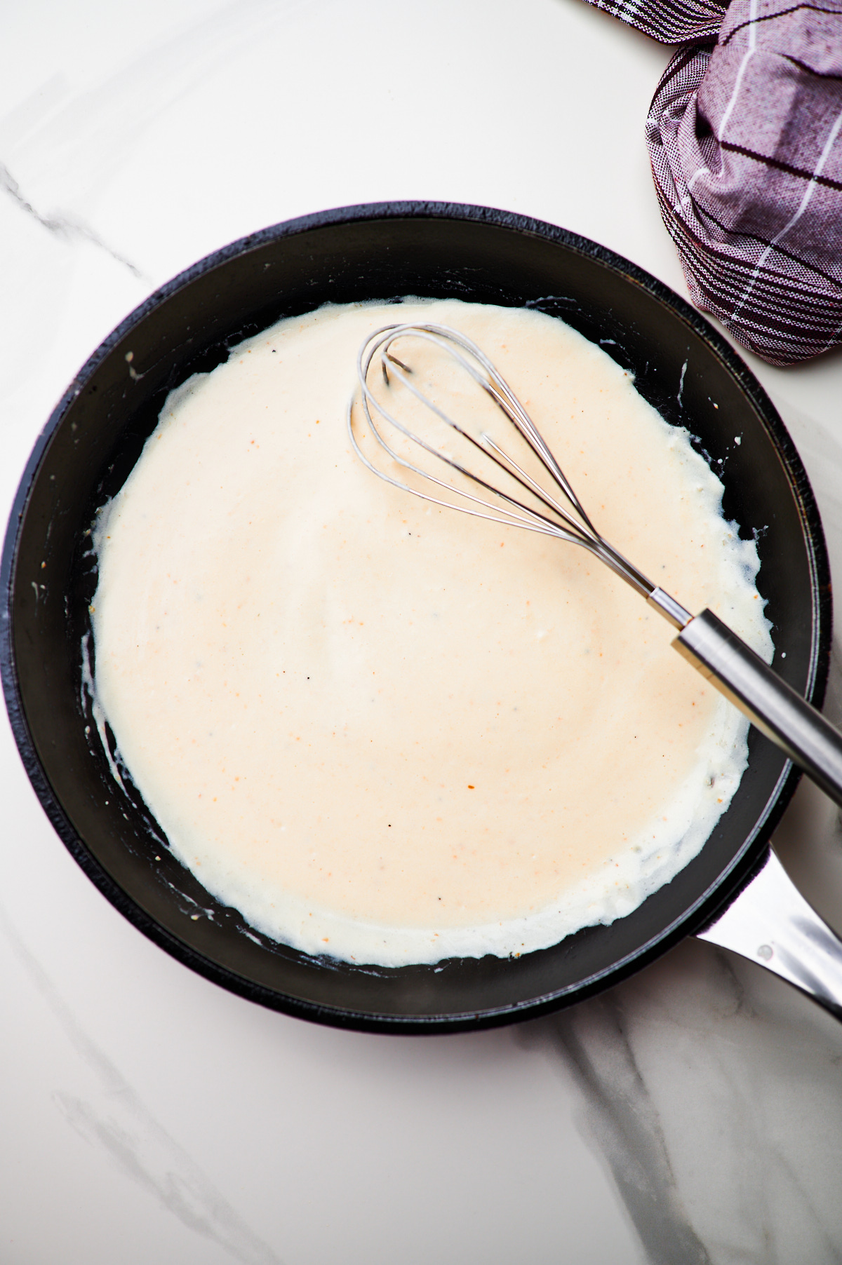 pan searing salmon fillet in a cast iron skillet and making the sauce for creamy salmon pasta in a skillet