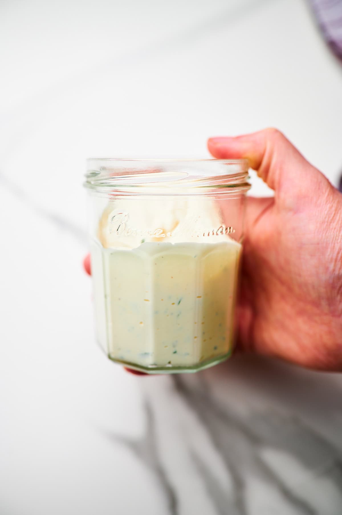 adding ingredients for ranch dressing to a mason jar and then shaking it up